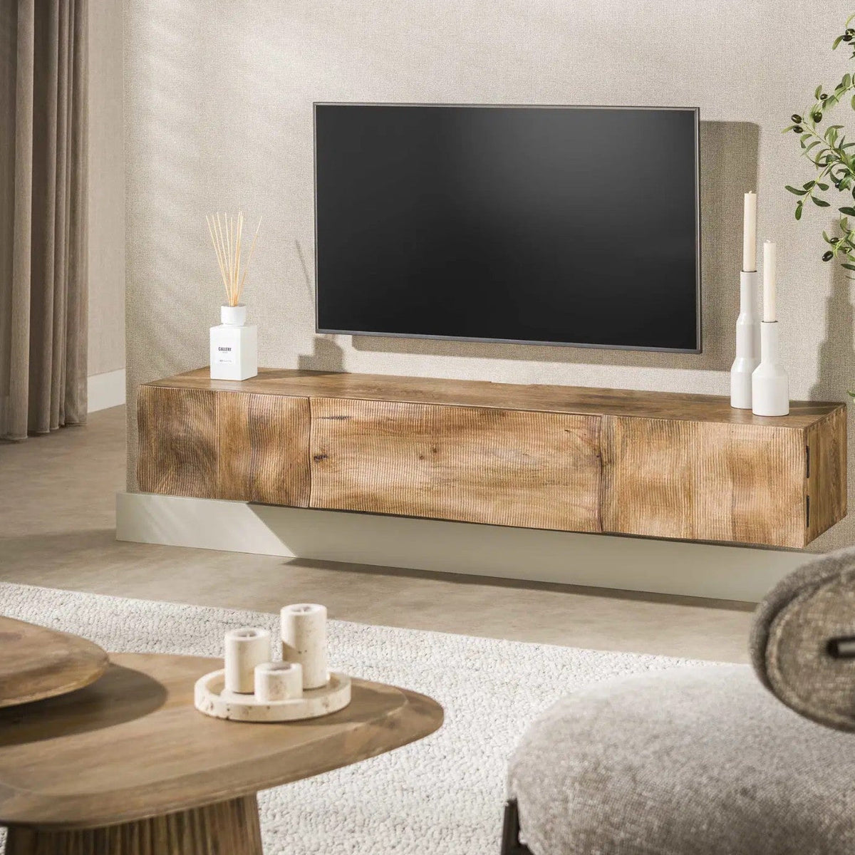Zwevend tv-meubel stylen: mangohout, zwart en keramiek in de woonkamer